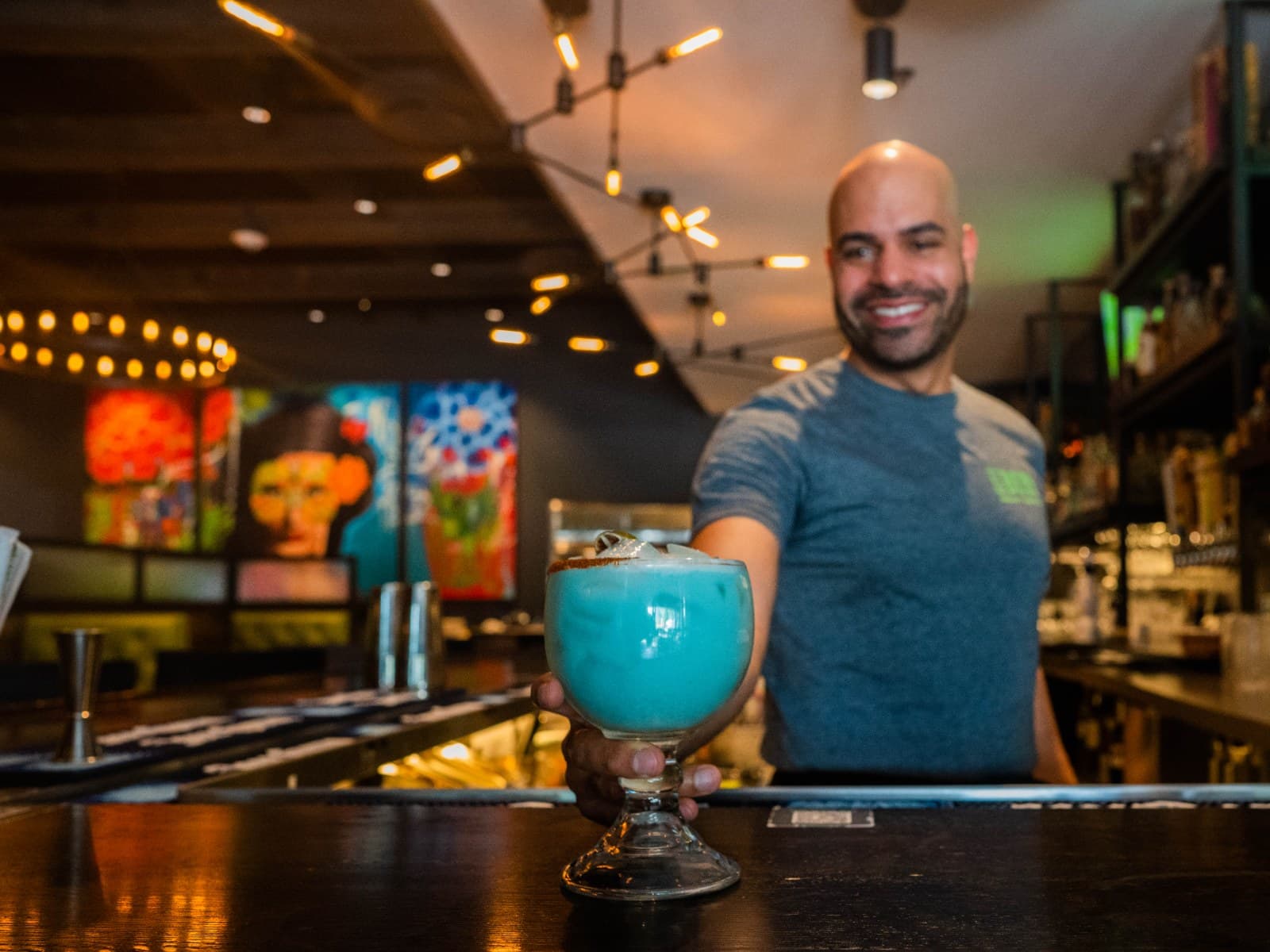 Bartender serving cocktails across the bar